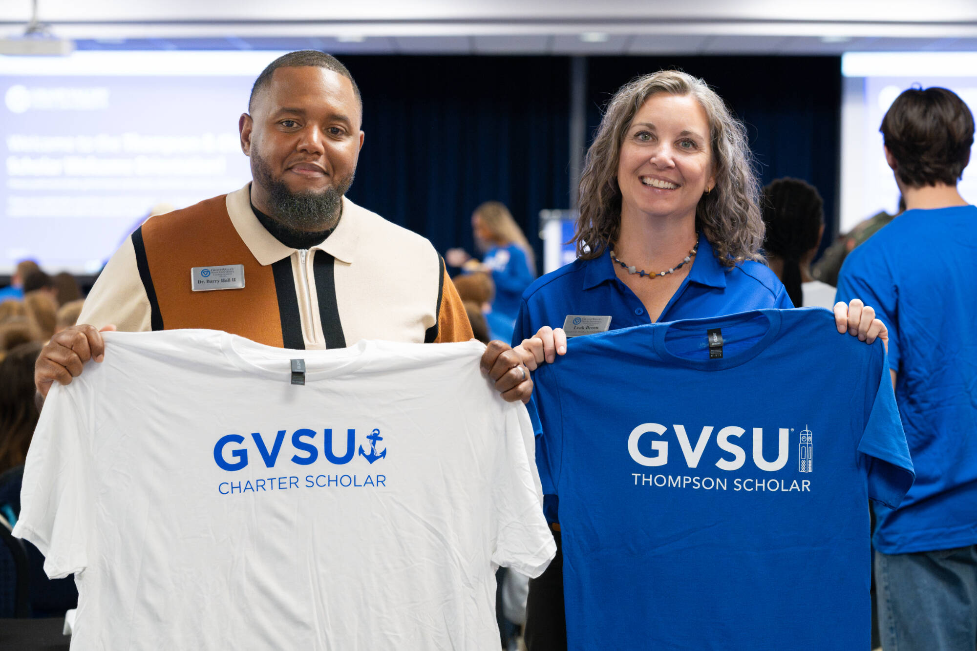 Photo of Dr. B and Leah from Division of K-12 Education Innovation and Scholar Success holding Thompson and Charter Scholars T-shirts